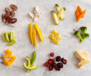 Fruits and vegetables cut into finger food shapes for 6-month-old baby.